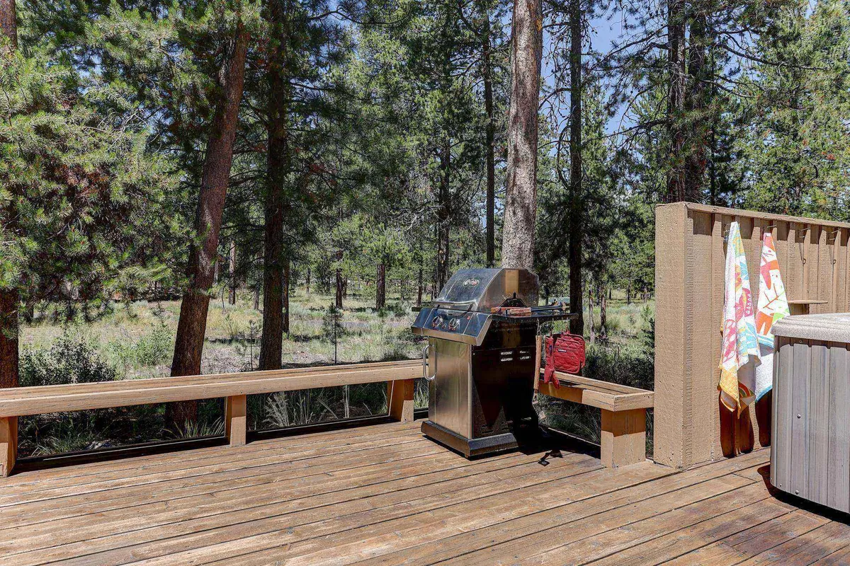 An inviting outdoor area with a grill, a wooden bench, and towels hanging nearby. The space suggests barbecuing, socializing, and enjoying time outdoors, possibly at sunset or under the stars.